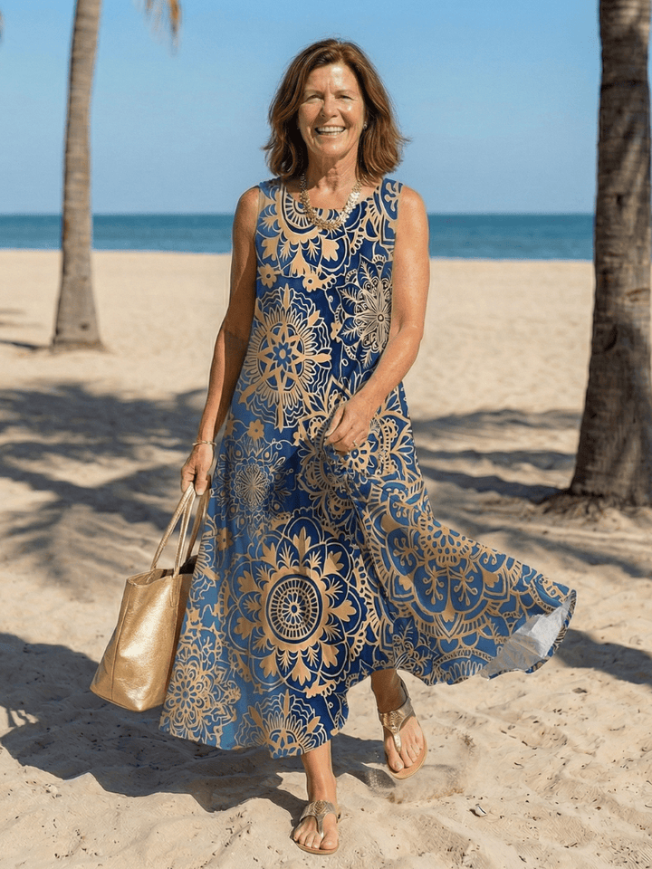 Neraya™ Open Air Midi Dress by Emma & Rose Cape Town displayed on a hanger with flowing fabric and intricate design details.