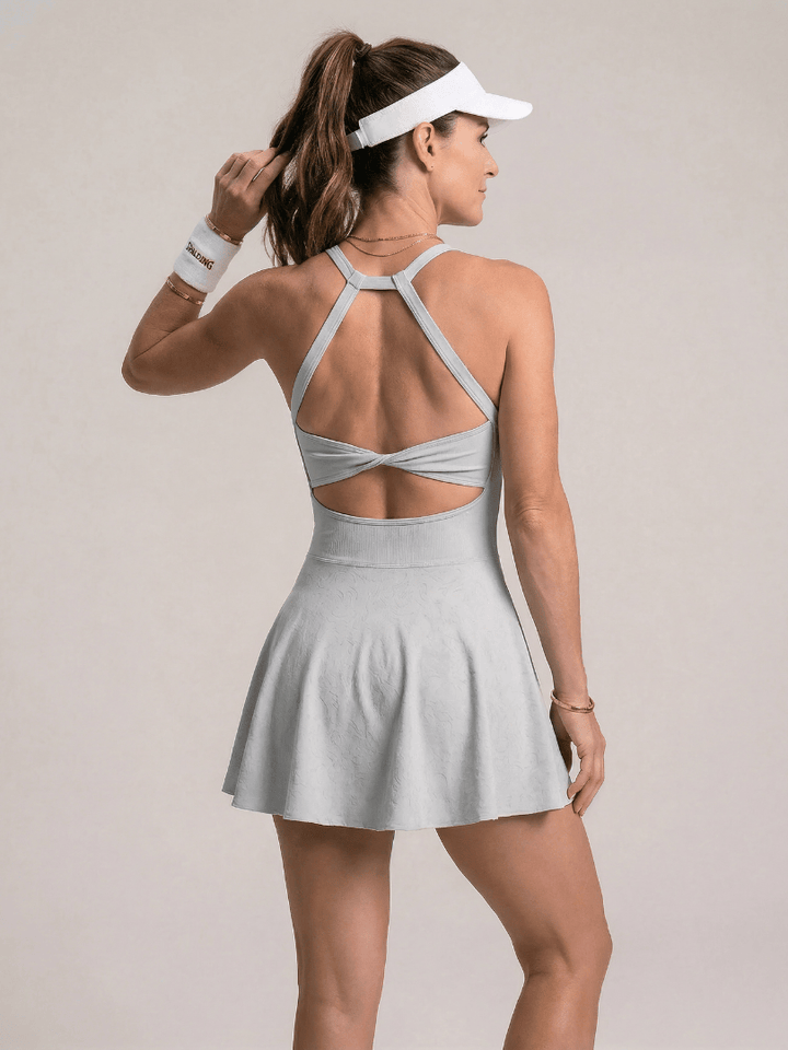 Emma & Rose Cape Town Zerelle™ strappy back tennis dress with fitted silhouette and athletic design, shown on a model.