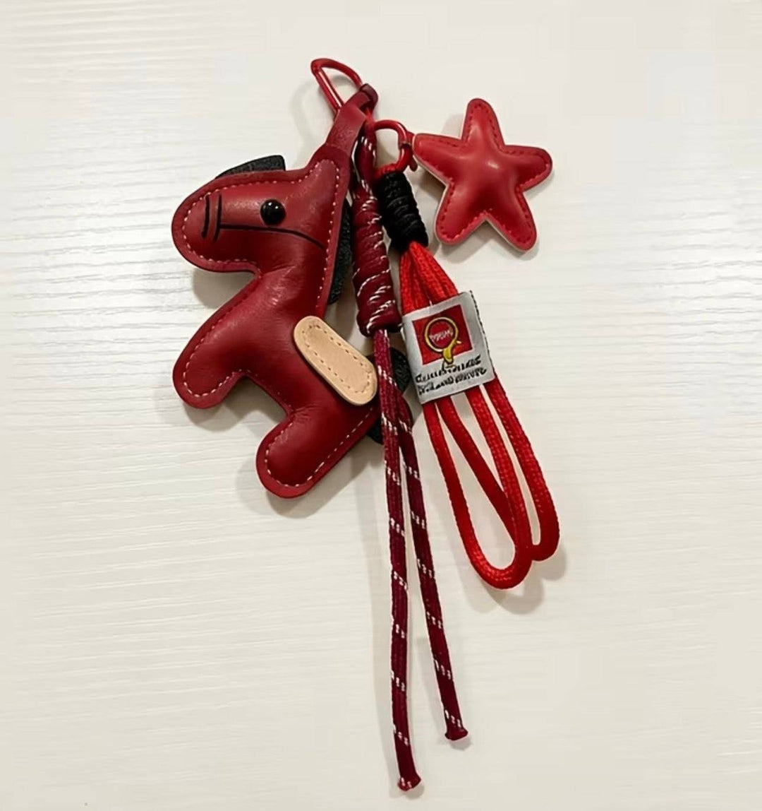 Emma & Rose Cape Town Hester™ pony-shaped bag charm hanging from a purse, detailed with colorful features and playful design.