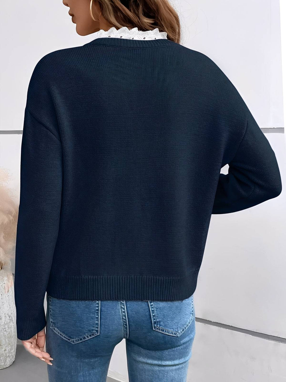 Navy Kaitlyssa™ elegant sweater by Emma & Rose Cape Town, displayed on a hanger with a textured knit pattern.