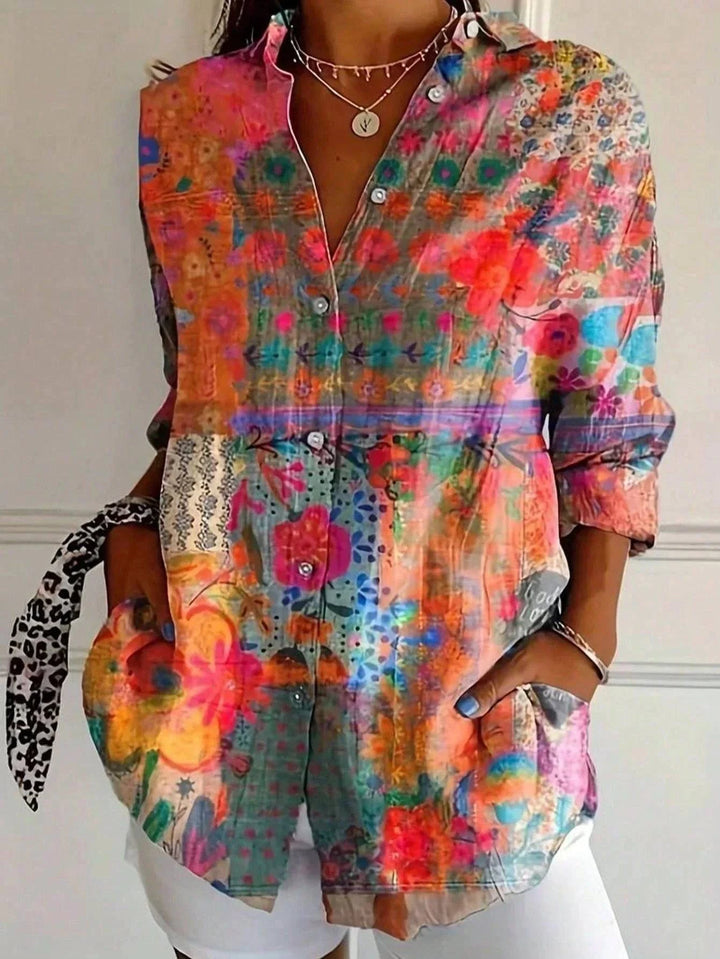 Astrid™ colorful patterned blouse by Emma & Rose Durban, featuring vibrant design and lightweight fabric, displayed on a hanger.