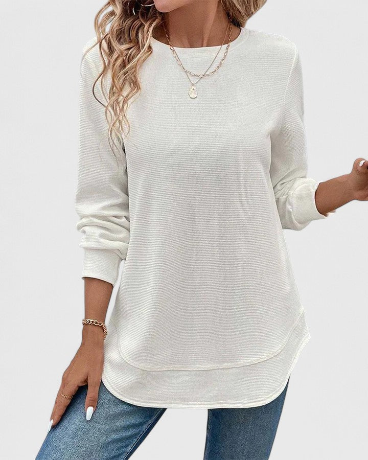 White Nadyalyn™ elegant O-neck long sleeve blouse from Emma & Rose Cape Town, shown on a hanger with detailed fabric texture.