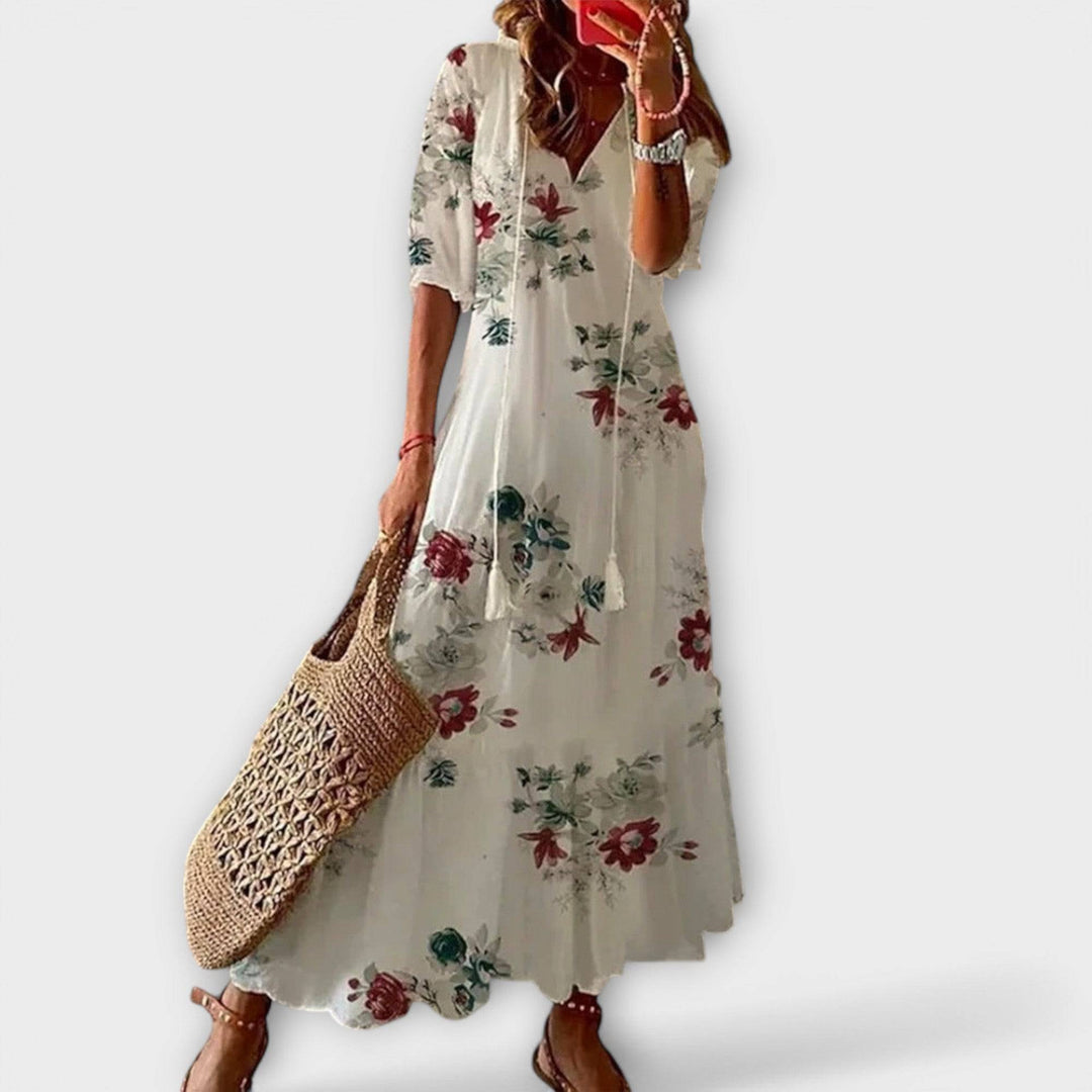 White Savannah™ elegant maxi dress by Emma & Rose Cape Town displayed on a hanger with flowing fabric and intricate detailing.